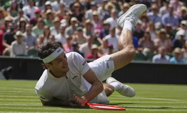 Taylor Fritz of the U.S. falls to the court after diving to return to Alejandro Davidovich Fokina of Spain during a third round singles match at the Wimbledon Tennis Championships in London, Friday, July 4, 2025. (AP Photo/Kin Cheung)