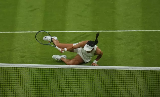 Emma Raducanu of Britain slips and falls attempting to return to Aryna Sabalenka of Belarus during a third round women's singles match at the Wimbledon Tennis Championships in London, Friday, July 4, 2025. (AP Photo/Joanna Chan)