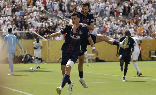 Paris Saint-Germain's Fabian Ruiz celebrates with team mate Khvicha Kvaratskhelia after scoring his side's opening goal during the Club World Cup semifinal soccer match between PSG and Real Madrid in East Rutherford, N.J., Wednesday, July 9, 2025. (AP Photo/Adam Hunger)