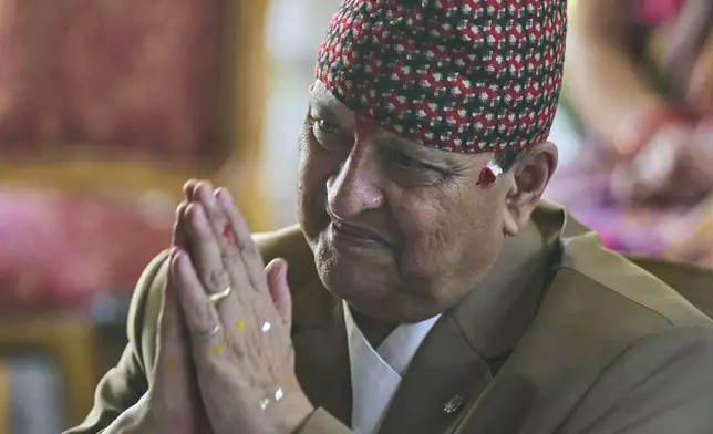Former King Gyanendra Shah acknowledges a supporter as others wait their turn to offer birthday wishes, at his residence in Kathmandu, Nepal, Monday, July 7, 2025. (AP Photo/Niranjan Shrestha)