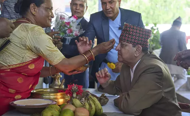 A supporter performs birthday rituals for former King Gyanendra Shah, right, at his residence, in Kathmandu, Nepal, Monday, July 7, 2025. (AP Photo/Niranjan Shrestha)