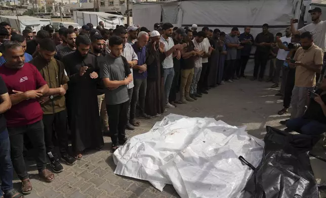 Mourners attend the funeral of members of Al-Aimawi family who were killed in an Israeli bombardment of Al-Zawaideh, at Al-Aqsa Hospital morgue in Deir al-Balah, Gaza Strip, on Tuesday, July 1, 2025. (AP Photo/Abdel Kareem Hana)