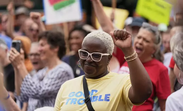 Tomesia Day raises her fist while listening to a speech during the annual Rep. John Lewis Way March, honoring the late congressman and civil rights leader, in Nashville, Tenn., Saturday, July 19, 2025. (AP Photo/George Walker IV)