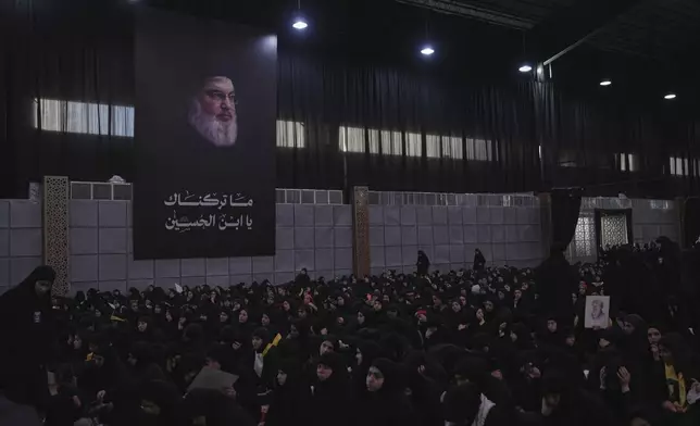 Hezbollah supporters attend a sermon beneath a large banner of Hezbollah leader Hassan Nasrallah during a religious gathering marking Ashoura, the Shiite Muslim commemoration of the 7th-century death of Imam Hussein, the grandson of the Prophet Muhammad, in the southern suburbs of Beirut, Lebanon, Sunday, July 6, 2025. (AP Photo/Hassan Ammar)