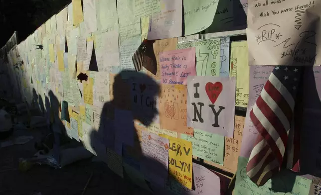FILE - Late evening shadows are cast across messages left by visitors on a wall standing in Union Square Park Wednesday, Sept. 11, 2002, in New York, to mark the one year anniversary of the Sept. 11 terrorist attacks. (AP Photo/Beth A. Keiser, File)