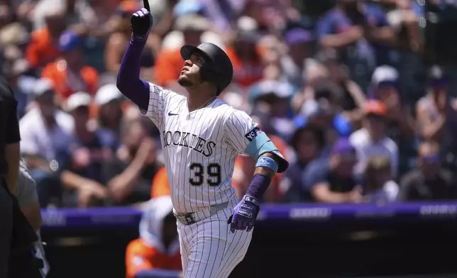Colorado Rockies' Thairo Estrada gestures as he circles the bases after hitting a two-run home run against Houston Astros starting pitcher Brandon Walter in the first inning of a baseball game, Thursday, July 3, 2025, in Denver. (AP Photo/David Zalubowski)