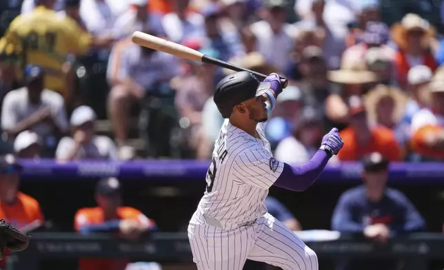 Colorado Rockies' Thairo Estrada follows the flight of his two-run home run off Houston Astros starting pitcher Brandon Walter in the first inning of a baseball game Thursday, July 3, 2025, in Denver. (AP Photo/David Zalubowski)