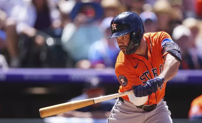 Houston Astros' Jose Altuve checks that he just earned a walk from Colorado Rockies starting pitcher Kyle Freeland in the fifth inning of a baseball game Thursday, July 3, 2025, in Denver. (AP Photo/David Zalubowski)