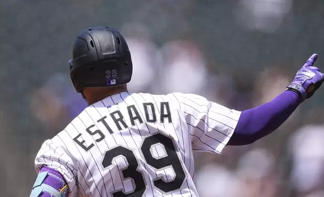 Colorado Rockies' Thairo Estrada gestures to the bullpen as he circles the bases after hitting a two-run home run off Houston Astros starting pitcher Brandon Walter in the first inning of a baseball game Thursday, July 3, 2025, in Denver. (AP Photo/David Zalubowski)