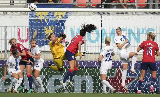 Norway's Ingrid Engen, center, tries to score past Finland goalkeeper Anna Koivunen during the Euro 2025, group A, soccer match between Norway and Finland at Stade de Tourbillon in Sion, Switzerland, Sunday, July 6, 2025. (AP Photo/Alessandra Tarantino)