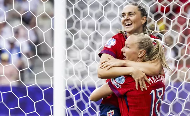 Norway's Vilde Boe Risa, top, and Norway's Frida Maanum, bottom, celebrate after Finland's Eva Nystrom scored an own goal during the Euro 2025, group A, soccer match between Norway and Finland in Sion, Switzerland, Sunday, July 6, 2025. (Jean-Christophe Bott/Keystone via AP)