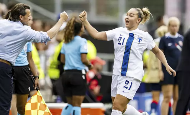 Finland's Oona Sevenius, right, celebrates with Finland's head coach Marko Saloranta, left, after scoring her side's first goal during the Euro 2025, group A, soccer match between Norway and Finland in Sion, Switzerland, Sunday, July 6, 2025. (Jean-Christophe Bott/Keystone via AP)