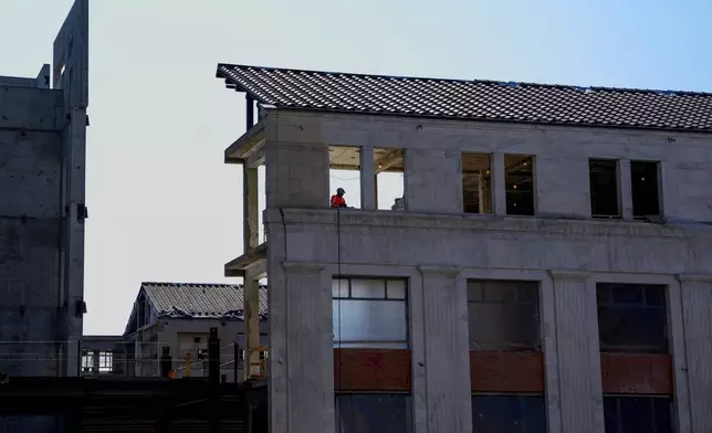 A worker is visible in the window of the 1951 Constitution Avenue Building as a renovations continue on the Federal Reserve, Thursday, July 24, 2025, in Washington. (Andrew Harnik/Pool Photo via AP)
