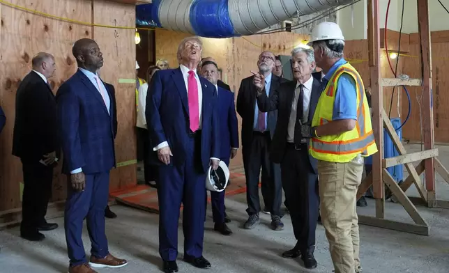 Sen. Tim Scott, R-S.C., from foreground left, President Donald Trump and Federal Reserve Chairman Jerome Powell visit the Federal Reserve, joined by Russell Vought, director of the Office of Management and Budget, in background third from right, Thursday, July 24, 2025, in Washington. (AP Photo/Julia Demaree Nikhinson)