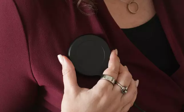 Brandy Ellis charges a pacemaker-like device that was installed in her chest as part of an experimental treatment for depression, on Thursday, July 24, 2025, in Delray Beach, Fla. (AP Photo/Marta Lavandier)
