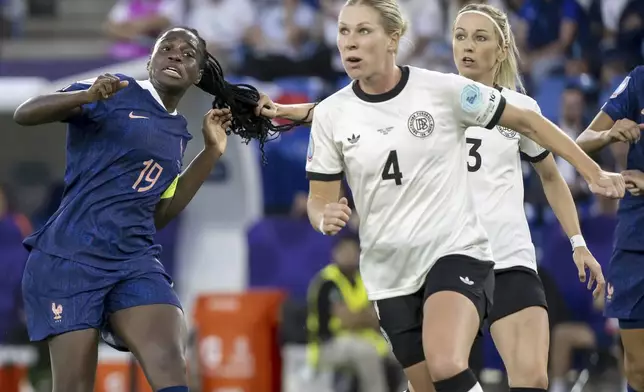 Germany's Kathrin Hendrich, right, pulls the hair of France's Griedge Mbock Bathy, left, to be shown a red card during the Women's Euro 2025 quarterfinals soccer match between France and Germany at St. Jakob-Park in Basel, Switzerland, Saturday, July 19, 2025. (Georgios Kefalas/Keystone via AP)