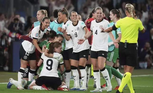 Germany players wait for Referee Tess Olofsson confirm that the last penalty saved by Germany goalkeeper Ann-Katrin Berger, kneeling, was valid after a penalty shootout at the end of the Women's Euro 2025 quarterfinals soccer match between France and Germany at St. Jakob-Park in Basel, Switzerland, Saturday, July 19, 2025. (AP Photo/Alessandra Tarantino)