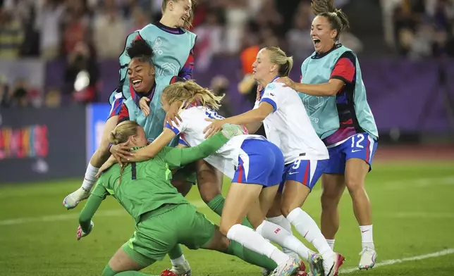 England players run to England goalkeeper Hannah Hampton celebrating after winning a penalty shootout at the end of the Women's Euro 2025 quarterfinals soccer match between Sweden and England at Stadion Letzigrund in Zurich, Switzerland, Thursday, July 17, 2025. (AP Photo/Alessandra Tarantino)