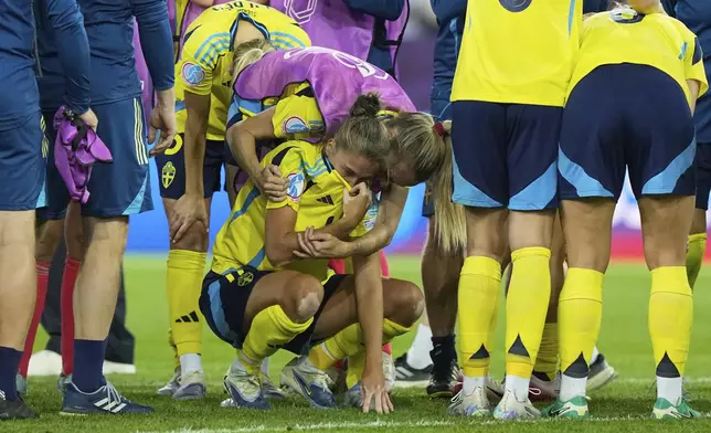 Sweden's Filippa Angeldahl is comforted by teammates after losing the Women's Euro 2025 quarterfinals soccer match between Sweden and England at Stadion Letzigrund in Zurich, Switzerland, Thursday, July 17, 2025. (AP Photo/Martin Meissner)