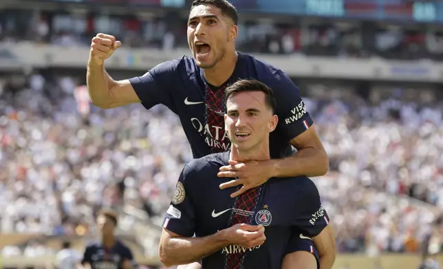 Paris Saint-Germain's Fabian Ruiz, bottom, celebrates with team mate Achraf Hakimi after scoring his side's third goal during the Club World Cup semifinal soccer match between PSG and Real Madrid in East Rutherford, N.J., Wednesday, July 9, 2025. (AP Photo/Adam Hunger)