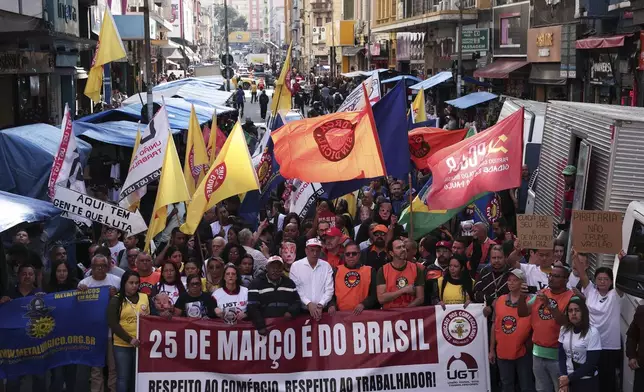 Merchants march on 25 de Marco street to protest U.S. President Donald Trump's announcement of 50% tariffs on Brazilian goods, and against U.S. report that cited this street as a center of counterfeit product sales in Brazil, in Sao Paulo, Friday, July 18, 2025. (AP Photo/Ettore Chiereguini)