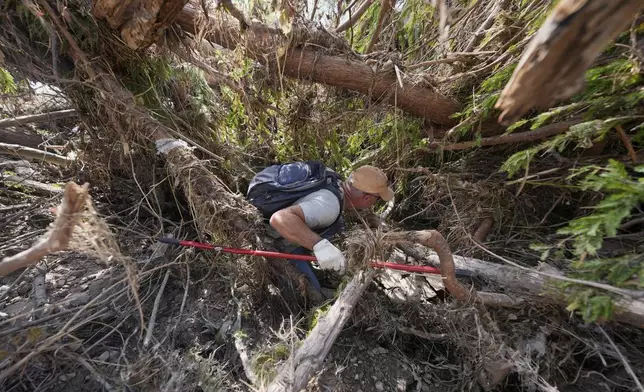 Kevin Scott searches for Aiden Heartfield, who went camping with friends and is missing along the Guadalupe River after flooding in Kerrville, Texas on Wednesday , July 9, 2025. (AP Photo/Gerald Herbert)