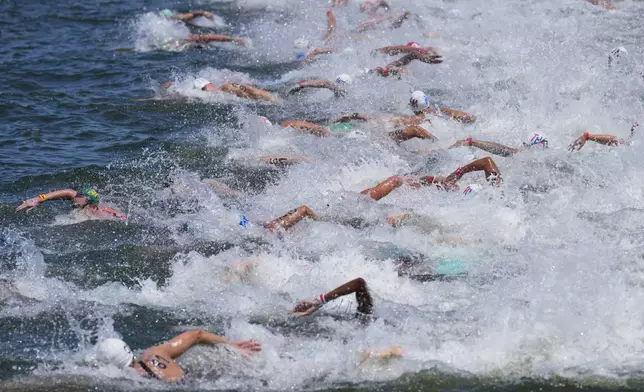 Swimmers compete in the men's 10km open water swim at the world swimming championships in Singapore, Wednesday, July 16, 2025. (AP Photo/Vincent Thian)