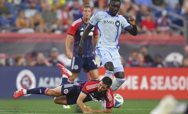 New England Revolution midfielder Matt Polster, below, and CF Montréal forward Prince Osei Owusu, top right, collide while pursing the ball during the first half of an MLS soccer match, Friday, July 25, 2025, in Foxborough, Mass. (AP Photo/Steven Senne)