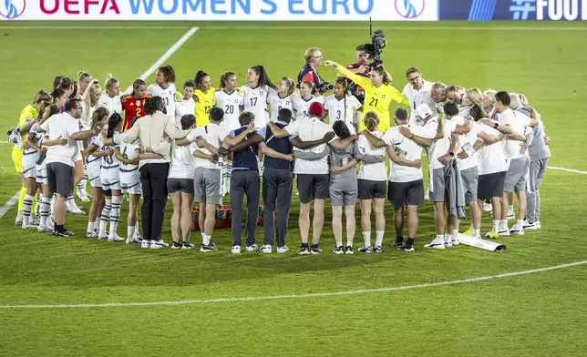 Switzerland players and staff gather at the center circle after the Women's Euro 2025 quarterfinals soccer match between Spain and Switzerland at Stadion Wankdorf in Bern, Switzerland, Friday, July 18, 2025. (Michael Buholzer/Keystone via AP)