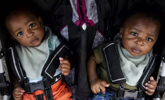 Seven-month-old twins Damonie and Dion Gill sit in a stroller together at the Flint Rx Kids Baby Parade event on July 25, 2025 in on Applewood Campus in Flint, Michigan. The event celebrates the continued impact of Rx Kids on Flint families and babies. (AP Photo/Emily Elconin)