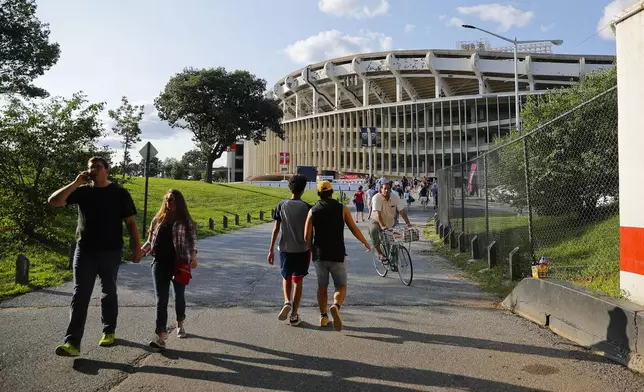 FILE - People make their way to RFK Stadium in Washington before the start of an MLS soccer match between D.C. United and Toronto FC, Saturday, Aug. 5, 2017. D.C. (AP Photo/Pablo Martinez Monsivais, File)
