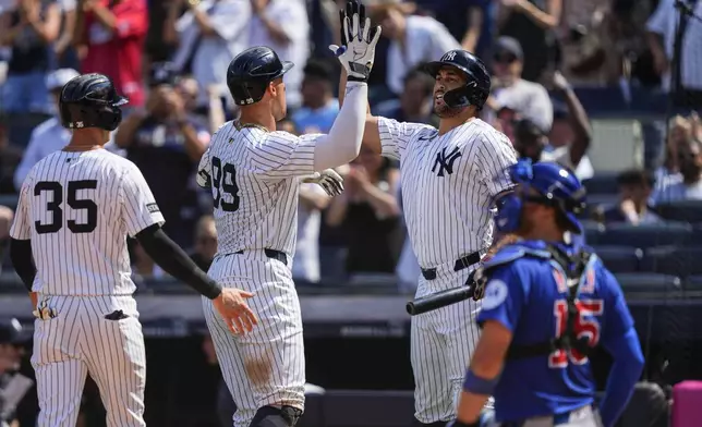 New York Yankees' Aaron Judge (99) celebrates with designated hitter Giancarlo Stanton (27) after hitting a two run home run during the ninth inning of a baseball game against the Chicago Cubs, Saturday, July 12, 2025, in New York. (AP Photo/Yuki Iwamura)