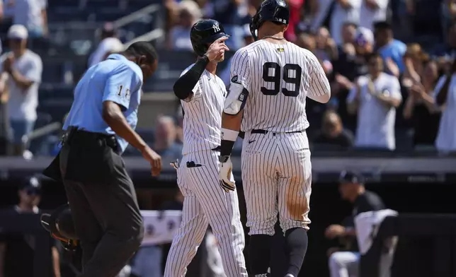 New York Yankees' Aaron Judge (99) celebrates with Cody Bellinger (35) after hitting a two run home run during the ninth inning of a baseball game against the Chicago Cubs, Saturday, July 12, 2025, in New York. (AP Photo/Yuki Iwamura)