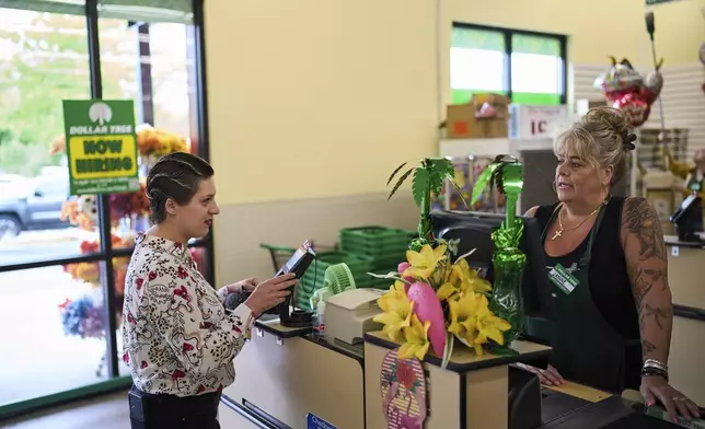Havalah Hopkins, a single mother who lives in government-subsidized housing with her teenage son, talks with a cashier as she buys some balloons for her son's birthday at a Dollar Tree, Thursday, July 10, 2025, in Woodinville, Wash. (AP Photo/Lindsey Wasson)
