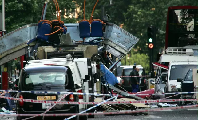 FILE - The wreckage of a double-decker bus with its top blown off by a bomb and damaged cars scattered on the road at Tavistock Square in central London, July 7, 2005. (AP Photo/Sang Tan, File)