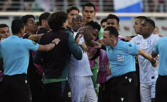 Honduras forward Romell Quioto, center, and Mexico's Guillermo Ochoa, left, have an altercation on the sideline during the first half of a CONCACAF Gold Cup semifinal soccer match Wednesday, July 2, 2025, in Santa Clara, Calif. (AP Photo/Godofredo A. Vásquez)