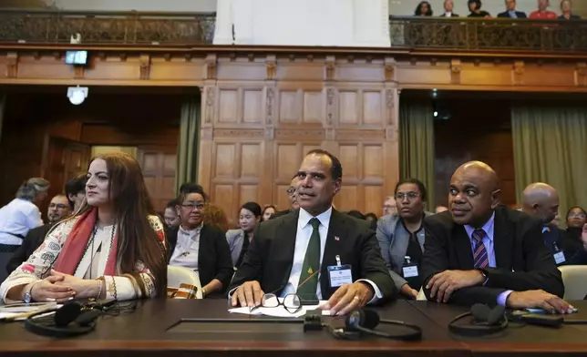 Ralph Regenvanu, center, Vanuatu's minister for climate change, arrives in the International Court of Justice, ahead of an advisory opinion on what legal obligations nations have to address climate change and what consequences they may face if they don't, Wednesday, July 23, 2025, in The Hague, Netherlands. (AP Photo/Peter Dejong)