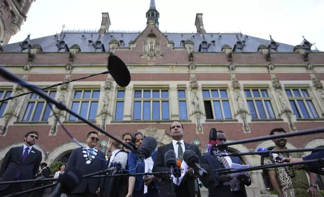 Ralph Regenvanu, center, Vanuatu's minister for climate change, speaks after the International Court of Justice's advisory opinion about nations' obligations to tackle climate change and consequences they may face if they don't, Wednesday, July 23, 2025, in The Hague, Netherlands. (AP Photo/Peter Dejong)