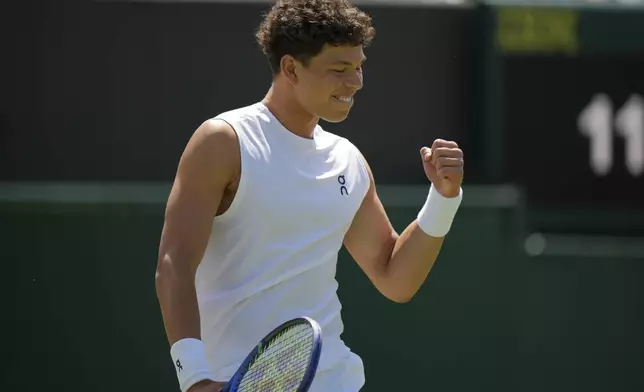 Ben Shelton of the U.S. celebrates winning the men's singles second round match against Rinky Hijikata of Australia at the Wimbledon Tennis Championships in London, Friday, July 4, 2025.(AP Photo/Alastair Grant)