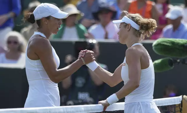 Laura Siegemund of Germany, right, greets Madison Keys of the U.S. at the net after winning their women's singles third round match at the Wimbledon Tennis Championships in London, Friday, July 4, 2025. (AP Photo/Alastair Grant)