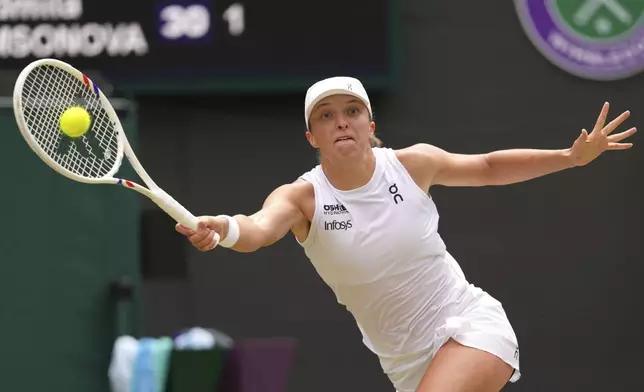 Iga Swiatek of Poland returns to Liudmilla Samsonova of Russia during the women's singles quarter final match at the Wimbledon Tennis Championships in London, Wednesday, July 9, 2025.(AP Photo/Kirsty Wigglesworth)