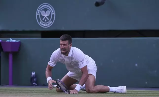 Serbia's Novak Djokovic reacts after slipping and falling when attempting a return to Italy's Flavio Cobolli during a quarterfinal men's singles match at the Wimbledon Tennis Championships in London, Wednesday, July 9, 2025. (AP Photo/Kin Cheung)