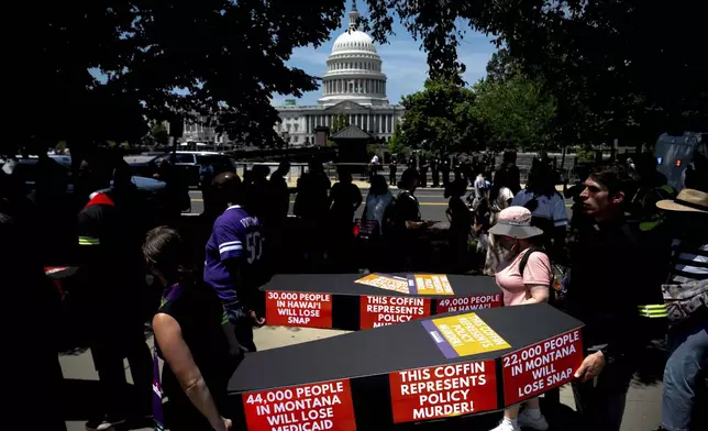 Demonstrators carry cardboard caskets in front of the U.S. Capitol in protest of President Donald Trump's tax breaks and spending cuts package, Monday, June 30, 2025, in Washington. (AP Photo/Julia Demaree Nikhinson)
