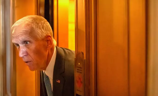 Sen. Thomas Tillis, R-N.C., leans out of an elevator to answer questions from reporters as Republicans begin a final push to advance President Donald Trump's tax breaks and spending cuts package, at the Capitol in Washington, Monday, June 30, 2025. (AP Photo/Mark Schiefelbein)