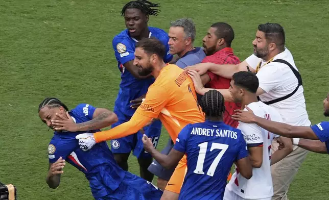 Chelsea's Joao Pedro, left, is attacked by Paris Saint-Germain's goalkeeper Gianluigi Donnarumma and coach Luis Enrique at the end of the Club World Cup final soccer match between Chelsea and PSG in East Rutherford, N.J., Sunday, July 13, 2025. (AP Photo/Pamela Smith)