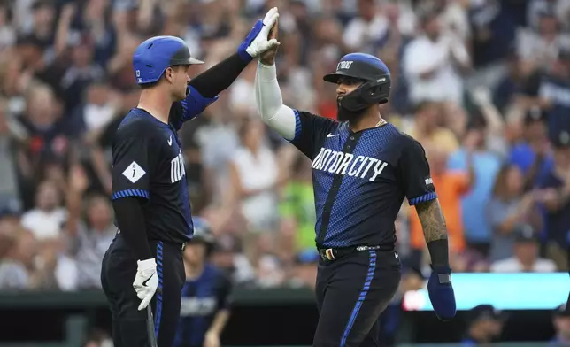 Detroit Tigers' Gleyber Torres, right, celebrates scoring with Dillon Dingler, left, against the Seattle Mariners in the fourth inning during a baseball game, Friday, July 11, 2025, in Detroit. (AP Photo/Paul Sancya)