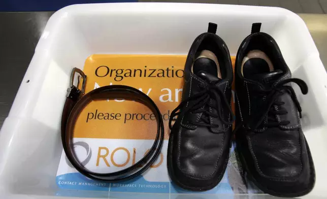 FILE - In this Wednesday, Jan. 10, 2007, file photo, a belt and shoes sit in a trays with advertising that is being used in the safety screening of travelers done by the Transportation Security Administration, at the Los Angeles International Airport in Los Angeles. (AP Photo/Ann Johansson, File)