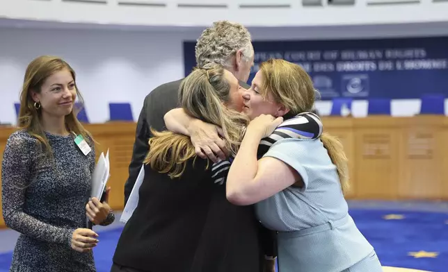 Agent to the European Court of Human Rights for the Government of the Kingdom of the Netherlands Babette Koopman, right, hugs plaintiffs after the European Court of Human Rights issued its judgment on Russian violations in Ukraine since 2014, including the downing of Malaysia Airlines flight MH17, Wednesday, July 9, 2025 in Strasbourg, eastern France. (AP Photo/Antonin Utz)