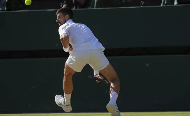 Serbia's Novak Djokovic returns to Italy's Jannik Sinner in a men's singles semifinal at the Wimbledon Tennis Championships in London, Friday, July 11, 2025. (AP Photo/Kin Cheung)