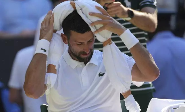 Serbia's Novak Djokovic tries to keep cool during a change of ends break against Italy's Jannik Sinner in a men's singles semifinal at the Wimbledon Tennis Championships in London, Friday, July 11, 2025. (AP Photo/Kin Cheung)